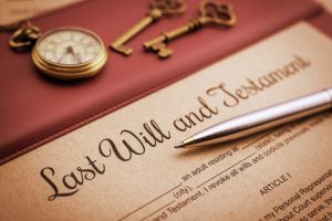 Vintage / retro style : Blue ballpoint pen, antique pocket watch, two brass keys and a last will and testament on a vinyl desk pad. A form is waiting to be filled and signed by testator / testatrix.