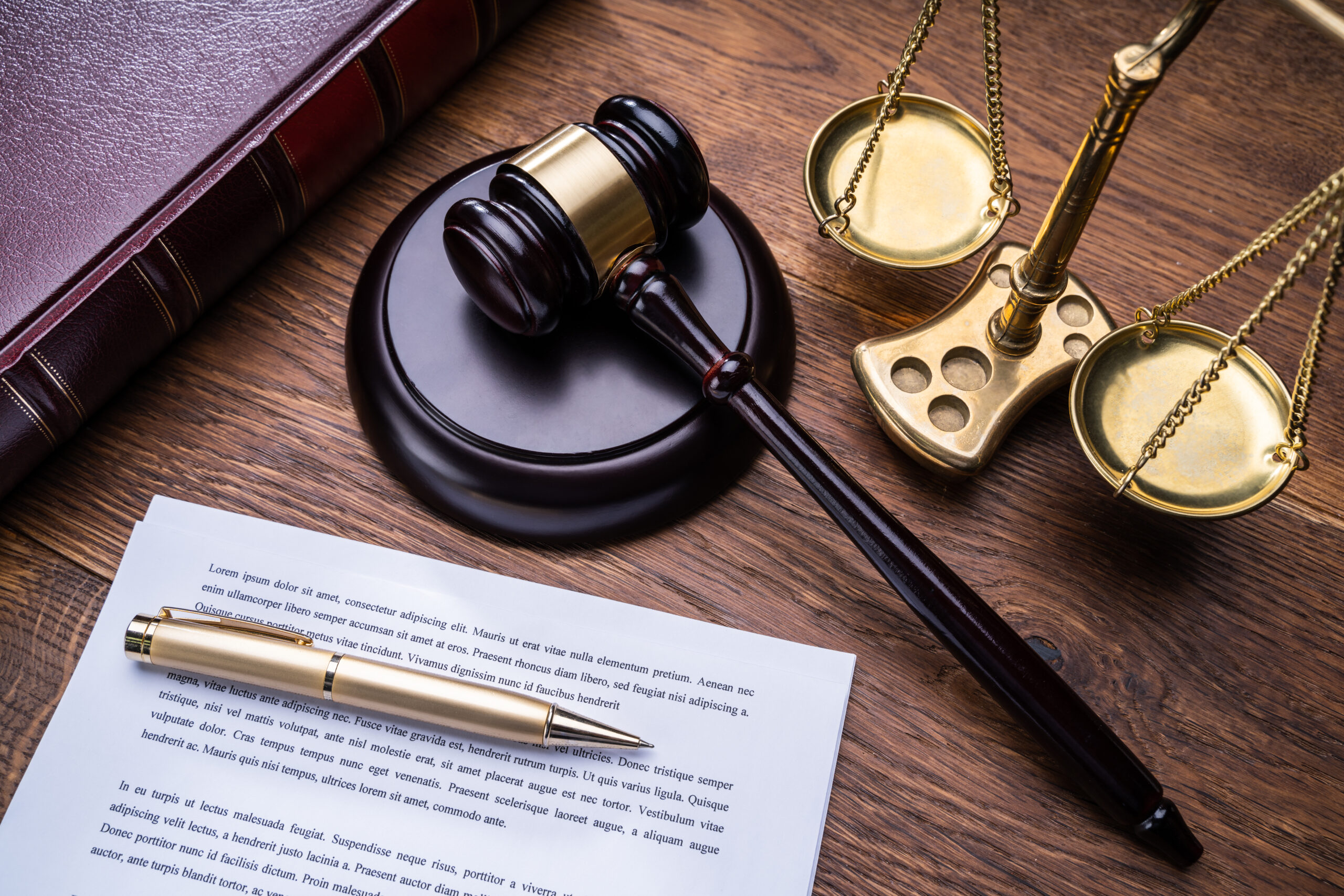 Wooden Gavel Golden Scale And Law Book On Table