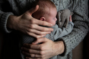 A father holding his baby son on his chest. Family bonding. Fatherhood